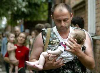 Офицер спецназа несет спасенного ребенка. Фото Reuters.
