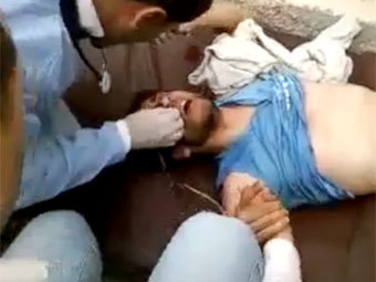 Врачи помогают раненному в Ливии демонстранту. Кадр видеозаписи очевидца с сайта libyafeb17.com