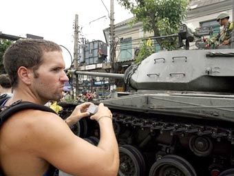 Туристы фотографируются на фоне танков в Бангкоке. Фото AFP 