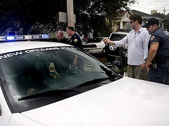 Ограбленный житель Нового Орлеана дает показания полиции. Фото ©AFP