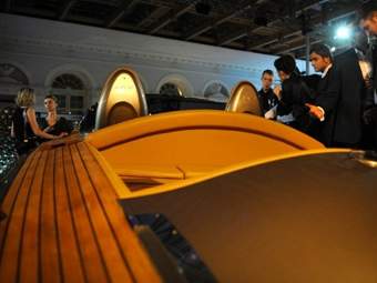 Гости Millionaire Fair на фоне выставленной в Манеже яхты. Фото ©AFP