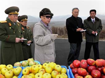 Ким Чен Ир и официальные лица на продуктовом рынке. Фото, переданное ©AFP