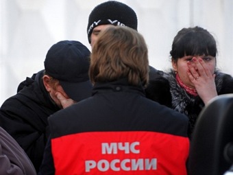 Сотрудник МЧС и родственники погибших на пожаре в Перми. Фото ©AFP