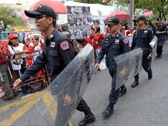Полиция Бангкока сдерживает демонстранотов "краснорубашечников". Фото ©AFP