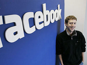 Марк Цукерберг на фоне логотипа Facebook. Фото ©AP
