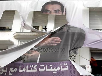 Жители Туниса срывают портрет бывшего президента. Фото (c)AP Жители Туниса срывают портрет бывшего президента. Фото (c)AP
