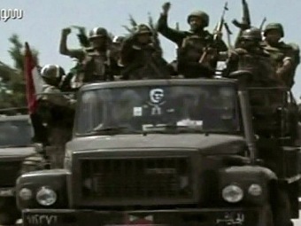 Сирийские войска на подходе к Джиср аль-Шугуру. Кадр сирийского телевидения, переданный (c)AFP Сирийские войска на подходе к Джиср аль-Шугуру. Кадр сирийского телевидения, переданный (c)AFP