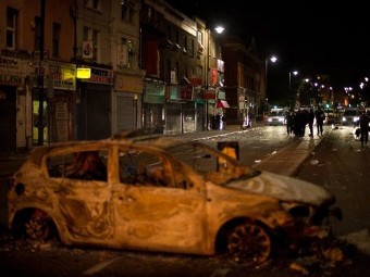 Выгоревшая полицейская машина в Тоттенхэме, 7 августа 2011 года. Фото (c)AFP Выгоревшая полицейская машина в Тоттенхэме, 7 августа 2011 года. Фото (c)AFP