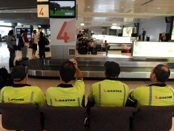 Грузчики Qantas во время забастовки. Архивное фото (c)AFP Грузчики Qantas во время забастовки. Архивное фото (c)AFP