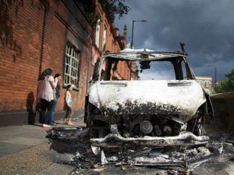 Сожженный в ходе августовских беспорядков автомобиль. Фото (c)AFP Сожженный в ходе августовских беспорядков автомобиль. Фото (c)AFP