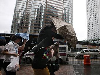 Пешеходы пытаются противостоять тайфуну в Гонконге. Фото (c)AP Пешеходы пытаются противостоять тайфуну в Гонконге. Фото (c)AP