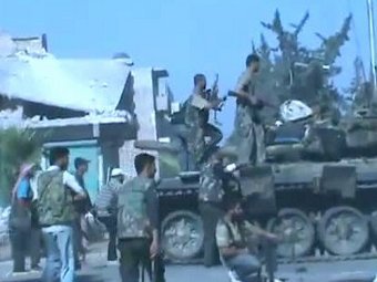 Повстанцы и танк, принадлежащий сирийской армии, в Алеппо. Кадр видеозаписи в YouTube, переданный (c)AFP Повстанцы и танк, принадлежащий сирийской армии, в Алеппо. Кадр видеозаписи в YouTube, переданный (c)AFP