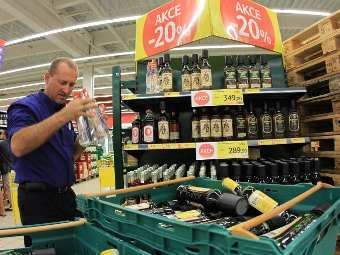 Сотрудник чешского супермаркета убирает крепкий алкоголь с полок. Фото ©AFP